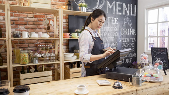 Barista taking an order on Popcorn POS at the cafe counter